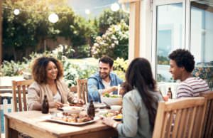 a group of friends eating on a backyard patio